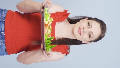 Vertikales-Video-Der-Person,-Die-Einen-Teller-Salat-Hält-Und-Lacht.